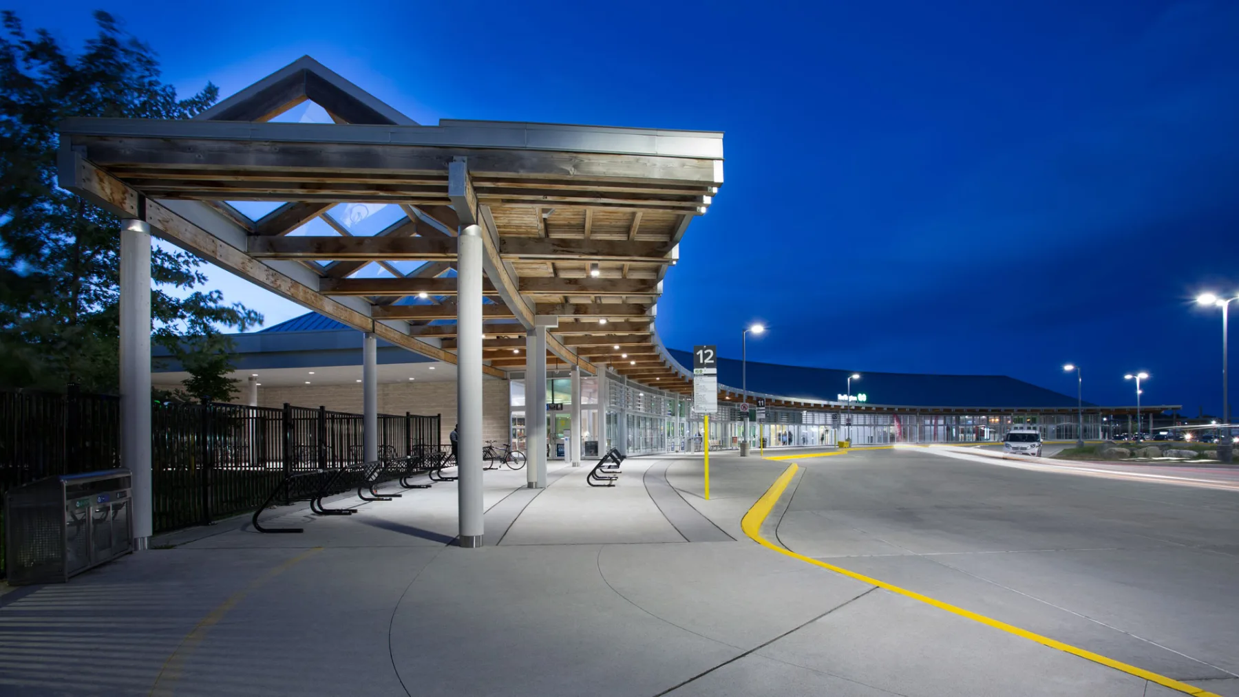 Exterior photo of the facility at night, showing the bike storage area