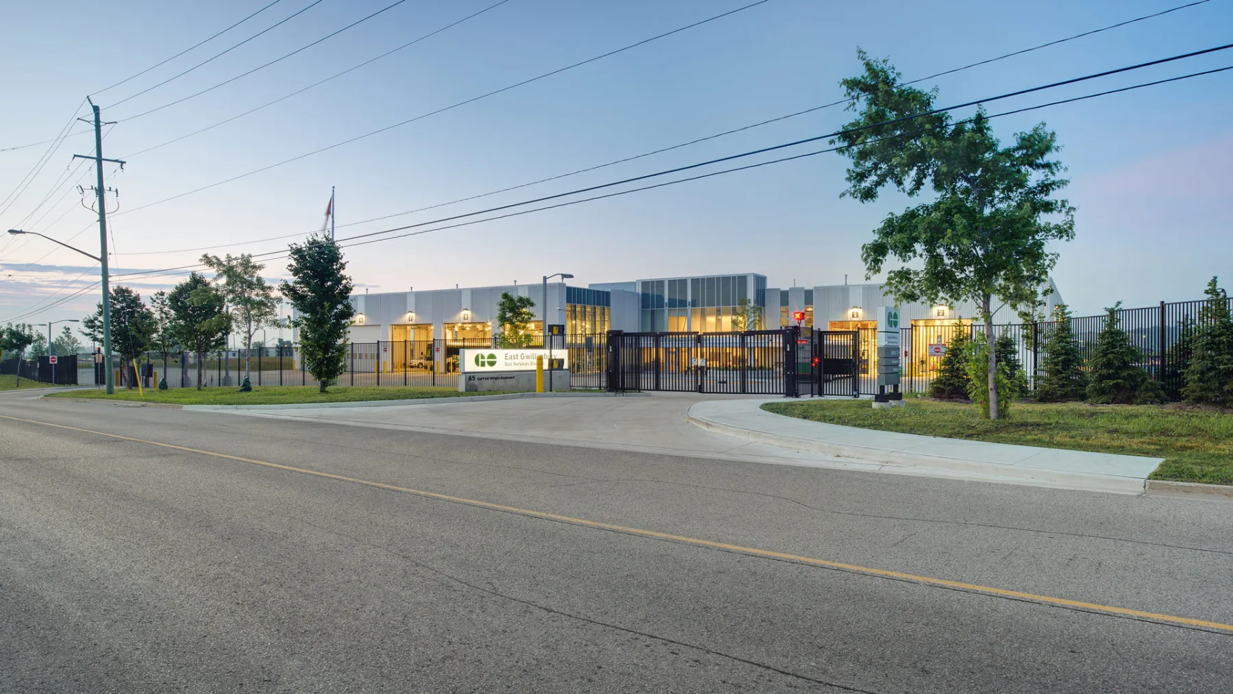 Exterior photo of the facility, showing the entire building, the gate and the road
