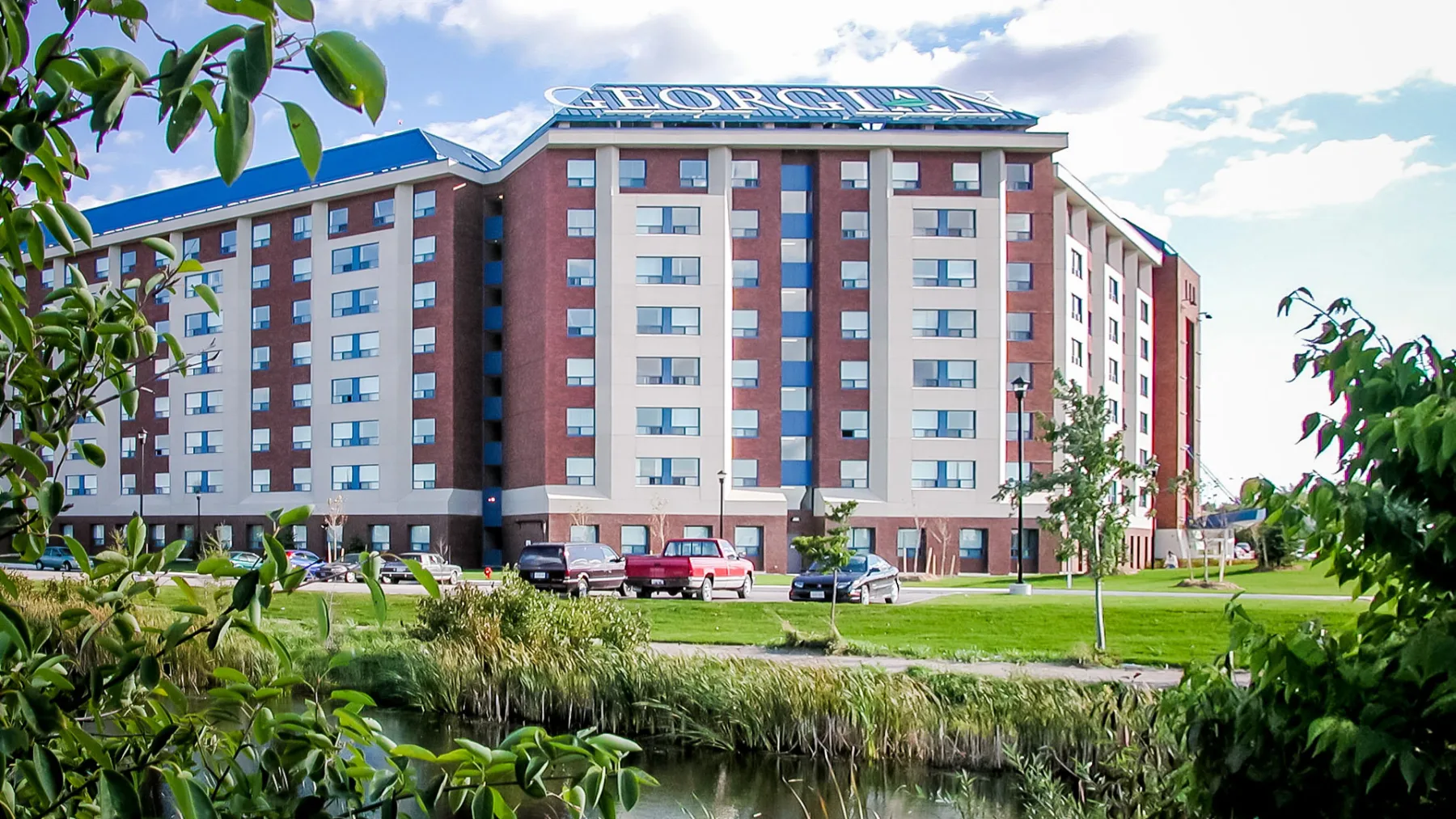 Exterior photo of the building with a pond and landscape in the front