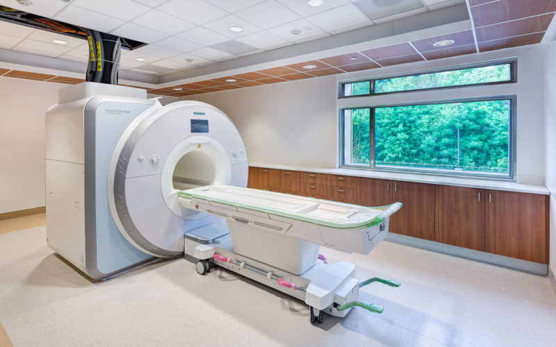 Interior photo of the MRI Suite with a window open to the wooded ravine