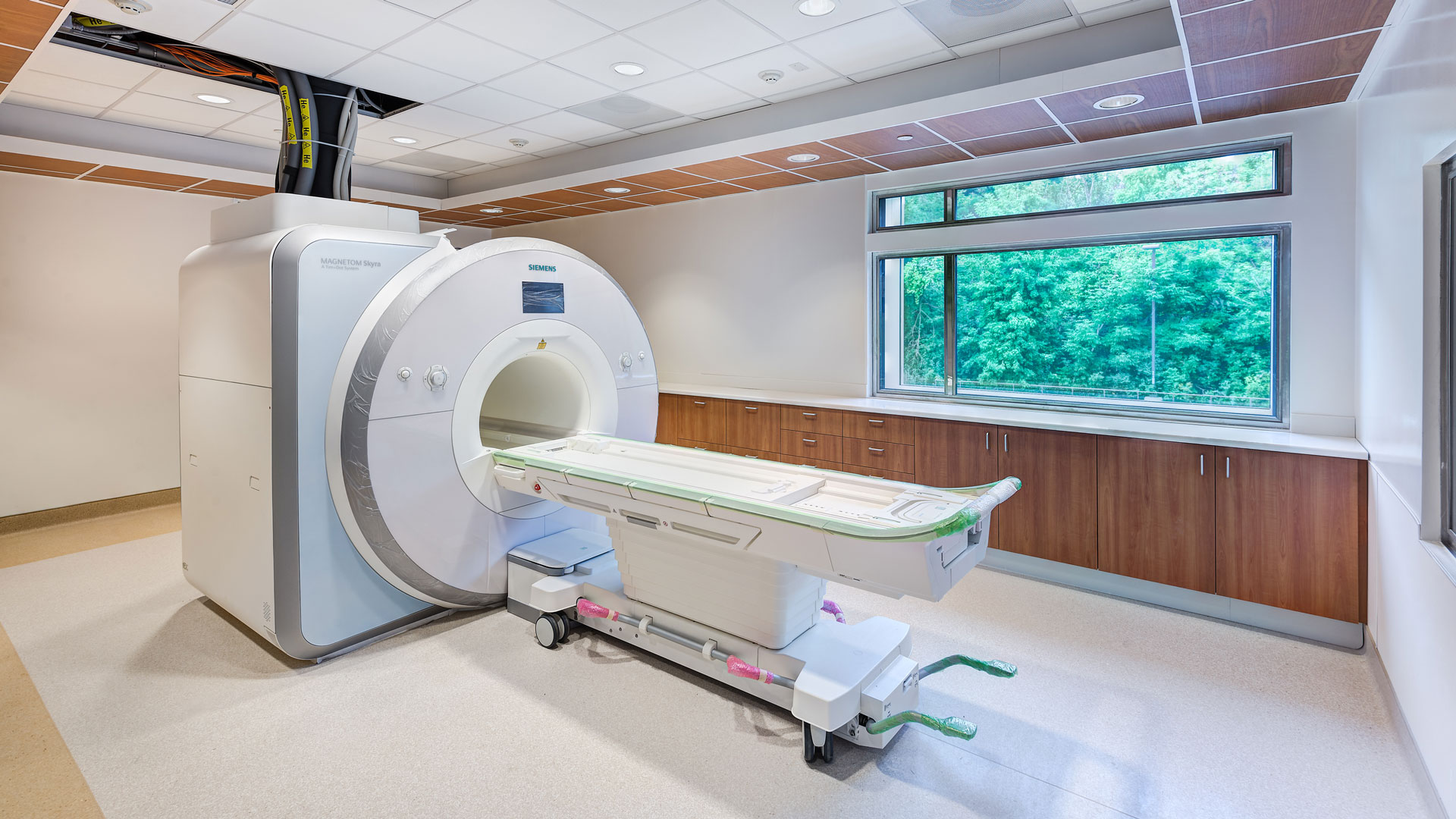 Interior photo of the MRI Suite with a window open to the wooded ravine