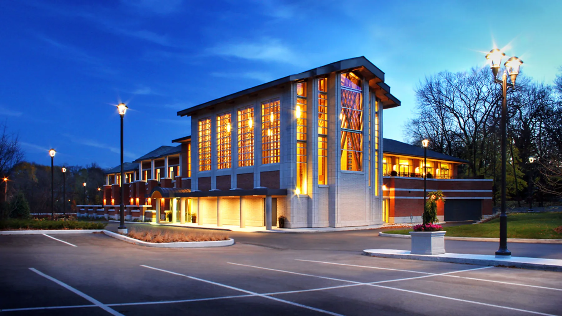 Exterior night photo of the chapel with parking lot in the front