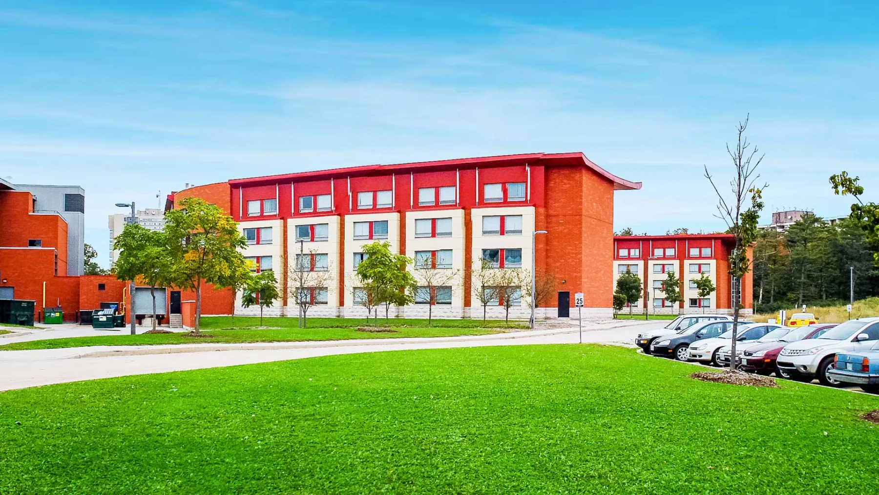 Exterior photo of the building showing the landscape, road and parking lot