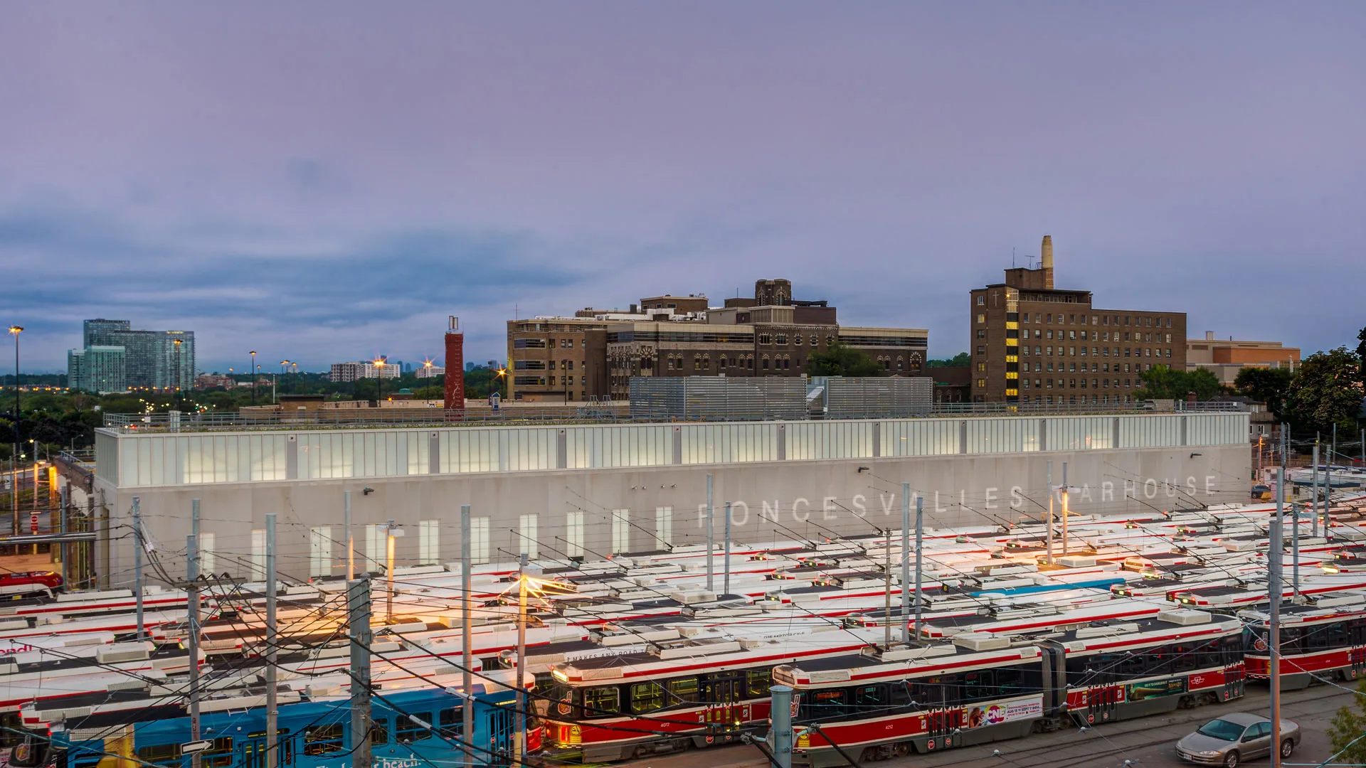 Exterior photo of the facility, showing the entire building, and streetcars parking in the train yard