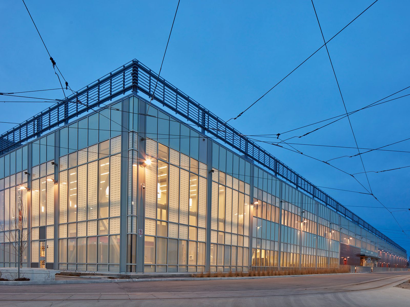 Exterior night photo of the building façade with floor-to-ceiling windows